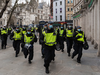 LONDON, UNITED KINGDOM - APRIL 03, 2021: Police officers run to cordon off demonstrators in central London after a protest against governmen...