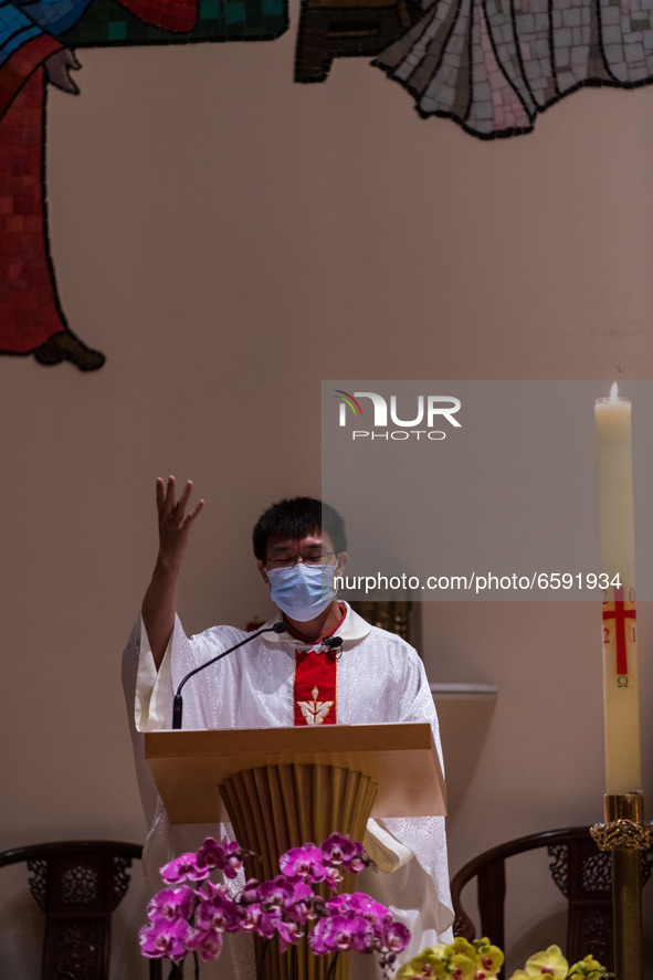A priest exhorts his faithful in the closing moments of his homily during the Easter mass at Our Lady of Mount Carmel Church in Wanchai. 