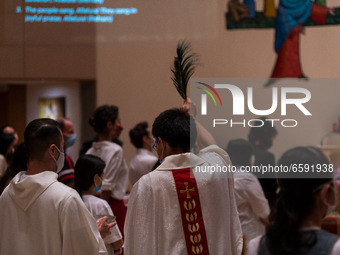 A Catholic priest carries out the traditional blessing of the faithful during the Easter mass at Our Lady of Mount Carmel in Wanchai. (