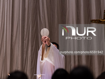 Hong Kong, China, 4 Apr 2021, A Catholic priest in the moment of elevation during the Easter mass at Our Lady of Mount Carmel in Wanchai. (