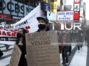 People participate at a rally in Times Square to empower and uplift the Asian community as hate spreads across the US, on April 4, 2021 in N...