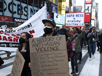 People participate at a rally in Times Square to empower and uplift the Asian community as hate spreads across the US, on April 4, 2021 in N...