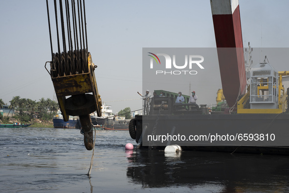 A man directing the rescue team from the rescue ship while trying to recover a capsized boat in Shitalakshya River, in Narayanganj on April...