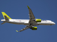 Air Baltic Airbus A220-300 aircraft as seen during take off and flight, departing from Amsterdam Schiphol AMS EHAM airport in the blue sky....