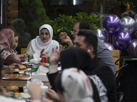 Iranian families living in the holy city of Qom, 145Km (90 miles) south of Tehran, speak with each other as they sit at a fast-food restaura...