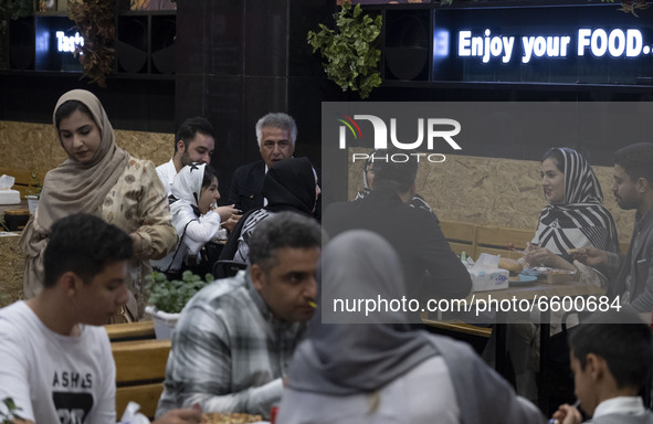 An Iranian family living in the holy city of Qom, 145Km (90 miles) south of Tehran, speak with each other as they sit at a fast-food restaur...