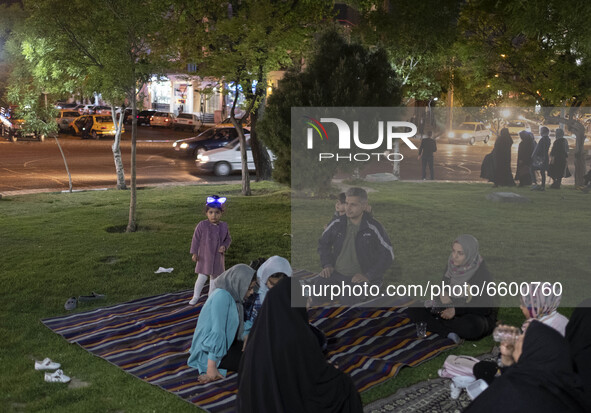 An Iranian family living in the holy city of Qom, 145Km (90 miles) south of Tehran, sit on a green area at night amid the new coronavirus di...