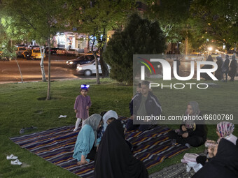 An Iranian family living in the holy city of Qom, 145Km (90 miles) south of Tehran, sit on a green area at night amid the new coronavirus di...