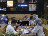 Iranian families living in the holy city of Qom, 145Km (90 miles) south of Tehran, at a fast-food restaurant at night amid the new coronavir...