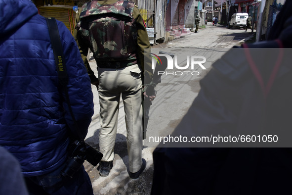 An Indian policeman holds a pump action pellet gun in a residential area where militants were believed to be trapped during cordon in Gulab...