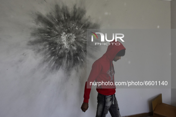 A Kashmiri boy assess the damaged residential house where the militants were believed to be trapped during cordon in Gulab Bagh area of Srin...