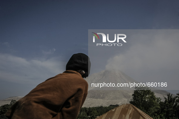 KARO, INDONESIA - JUNE 29: A child standing on the truck look volcanic plume forms as Mount Sinabung undergoes a volcanic spew on June 29, 2...