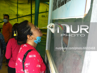 A health worker takes a swab sample from a woman for a Rapid Antigen Testing (RAT)  at a test centre, in Guwahati ,India on April 8, 2021....