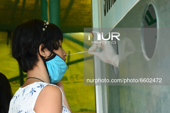 A health worker takes a swab sample from a girl  for a Rapid Antigen Testing (RAT)  at a test centre, in Guwahati ,India on April 8, 2021.  