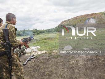 Soldiers shoots a grenade with the assistance of a military instructor of the DPR army in the outskirts of Donetsk city on June 29, 2015. (P...