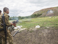 Soldiers shoots a grenade with the assistance of a military instructor of the DPR army in the outskirts of Donetsk city on June 29, 2015. (