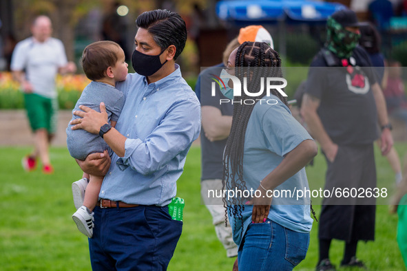 Aftab Pureval, the Hamilton County Clerk of Courts, holds a baby as people gather at Washington Park in memorial and then march to where Tim...
