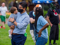 Aftab Pureval, the Hamilton County Clerk of Courts, holds a baby as people gather at Washington Park in memorial and then march to where Tim...
