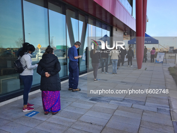 People wait outside a COVID-19 vaccination centre at the Aaniin Community Centre in Markham, Ontario, Canada on April 07, 2021. To combat th...