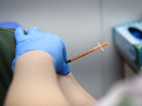 A syringe is seen in the arm of a soldier during a COVID-19 vaccination in Warsaw, Poland on April 8, 2021. The Polish army has set up a tem...