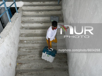 A volunteer carrying units of Electronic Voting Machine ( EVM ) from a locker of a safe house ahead of West Bengal Assembly elections in Kol...