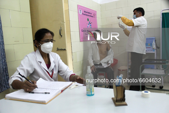 A man receives a dose of COVISHIELD coronavirus disease (COVID-19) vaccine manufactured by Serum Institute of India, at a government hospita...