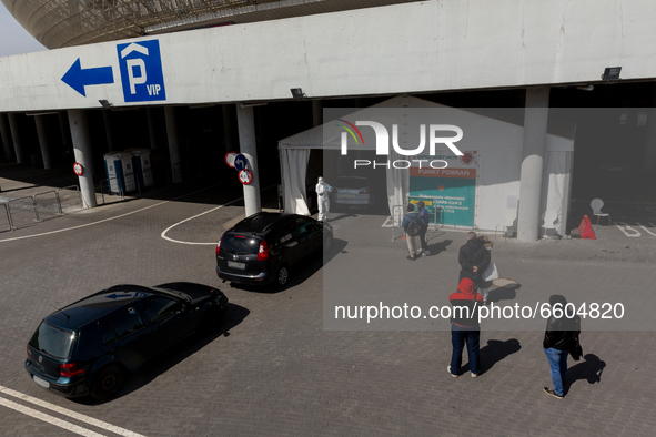 Cars and pedestrians wait in a queue to the PCR Coronavirus drive thru testing site at Touron Arena on April 9, 2021 in Krakow, Poland. Numb...