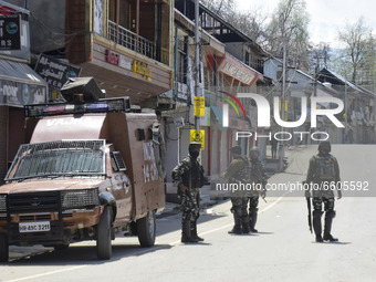 Indian forces remain alert next to the closed shops near a gun battle site in Shopian district of Indian Administered Kashmir on 09 April 20...