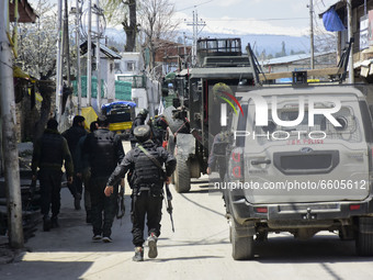 Indian forces rush towards the stranded vehicle near a gun battle site in Shopian district of Indian Administered Kashmir on 09 April 2021....