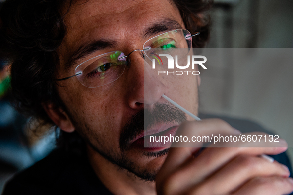 A man is rolling a swab firmly inside of his nostril making circles, during the realization of a Corona rapid self-test that from today peop...