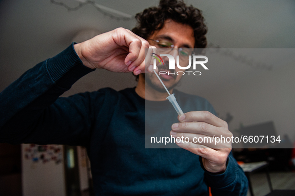 A man is placing the fabric tip of the swab in the extraction tube, during the realization of a Corona rapid self-test that from today peopl...