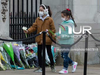 LONDON, UNITED KINGDOM - APRIL 10, 2021: Children carry flowers to place outside Buckingham Palace a day after the death of Prince Philip, o...