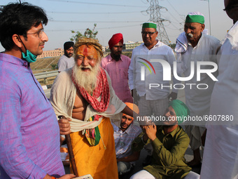 A farmer seeks support from a Sadhu (holy man) during a 24-hour blockade of KMP Expressway (Kundli–Manesar–Palwal) as part of their ongoing...