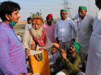 A farmer seeks support from a Sadhu (holy man) during a 24-hour blockade of KMP Expressway (Kundli–Manesar–Palwal) as part of their ongoing...