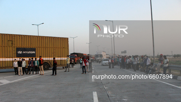 Commuters along with trucks stand stranded at KMP Expressway (Kundli-Manesar-Palwal) during a 24-hour blockade by farmers as a part of their...