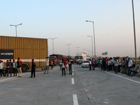Commuters along with trucks stand stranded at KMP Expressway (Kundli-Manesar-Palwal) during a 24-hour blockade by farmers as a part of their...