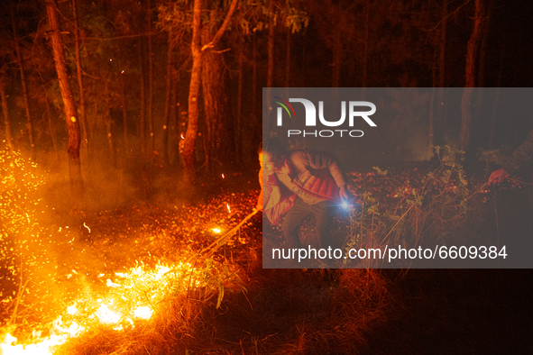 A resident tries to extinguish the fire in a forest of Nagarkot in Bhaktapur Nepal on April 11, 2021. 