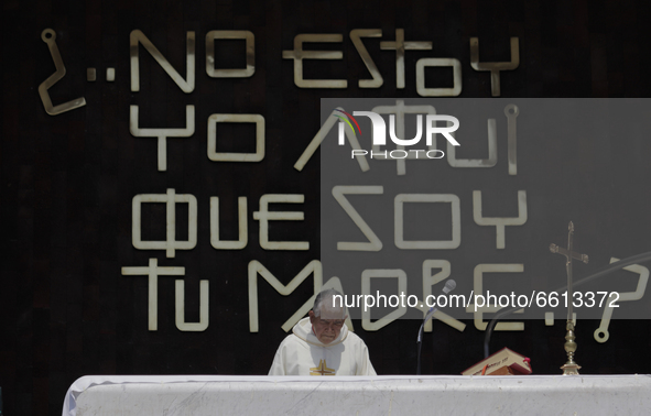 A priest officiates mass from the balcony of the Basilica of Guadalupe in Mexico City, Mexico, on April 11, 2021 during the health emergency...