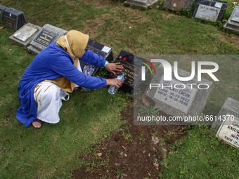 A woman performs rituals on a tombstone atCibarunai Tomb on 12, April, 2021 in Bandung, Indonesia. Before the month of Ramadan begins, Indon...