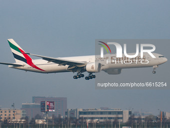Emirates Boeing 777-300ER aircraft as seen early morning flying on final approach for landing at Amsterdam Schiphol AMS EHAM international A...
