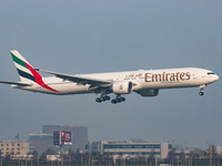 Emirates Boeing 777-300ER aircraft as seen early morning flying on final approach for landing at Amsterdam Schiphol AMS EHAM international A...