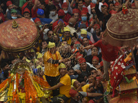 Nepalese Devotees exchanges a ritual torch after rotating during the celebration of Pahachare Chariot Festival at Ason, Kathmandu, Nepal on...