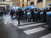 A police officer kicks away a flare  during a demonstration organised by the 'IoApro' (I open) movement  against restriction measures to cur...