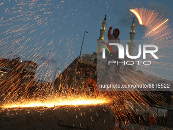 A Palestinian youth swings homemade fireworks sparklers, as people celebrate on the night ahead of the Muslim holy fasting month of Ramadan,...
