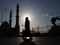 A Palestinian woman walks near a mosque in Gaza City on April 12, 2021, before the first sunset marking the start of the Muslim holy fasting...