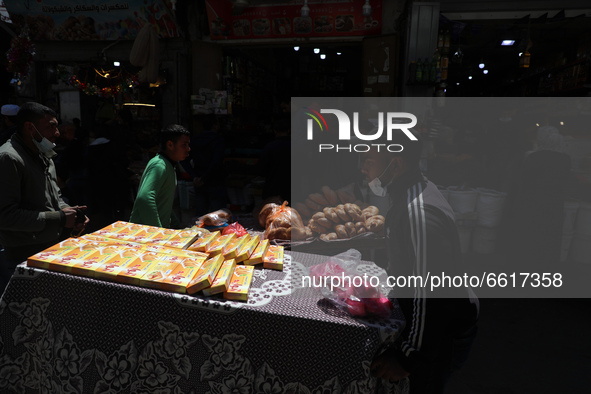 A Palestinian hawker wheels his wares in the market during the first day of the holy fasting month of Ramadan, in Gaza City, Tuesday, April...