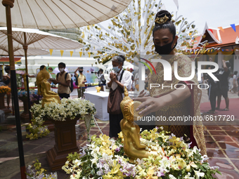 People queue to pour water on a Buddhist statue as they celebrate Songkran, also known as the Thai New Year, at Wat Pho temple in Bangkok, T...