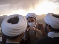 Clerics speak with each other during a ceremony for observation of the new moon of Muslim’s holy month of Ramadan in the Imam Ali observator...