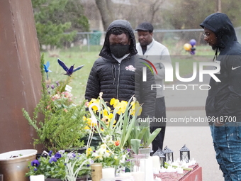 Two men look at flowers, candles, and signs at a makeshift memorial for Daunte Wright in Brooklyn Center, Minnesota, USA on April 13, 2021....