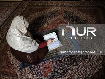 A Woman reciting holy book of Quran on the 1st day of the Holy month of Ramadan at her home amid COVID-19 Coronavirus pandemic in Sopore, Di...